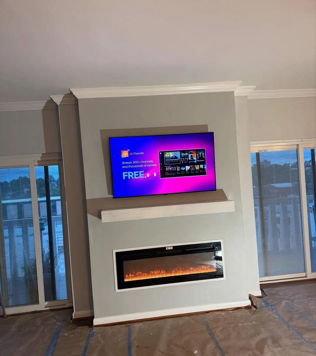 Finished wall with an electric fireplace and a mounted TV